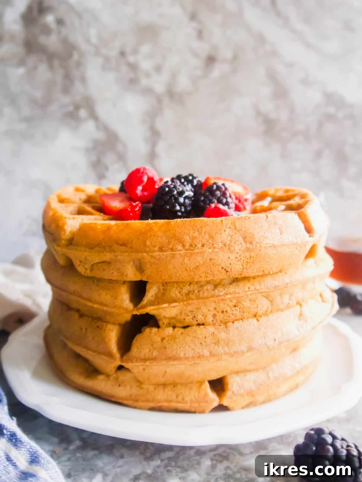 Two gluten-free Belgian waffles, perfectly golden and stacked on a plate.