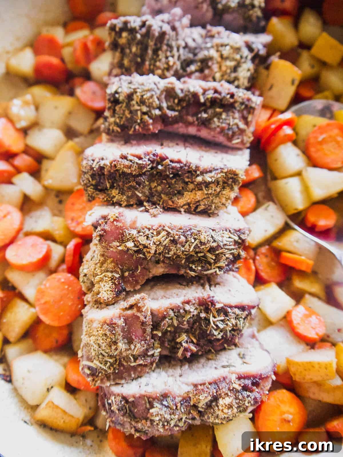 Dutch Oven Roasted Pork Loin with Sticky Spiced Fruit Glaze 3 Beautifully sliced Baked Pork Loin revealing tender meat, served in a Dutch oven with caramelized pears and tender carrots.