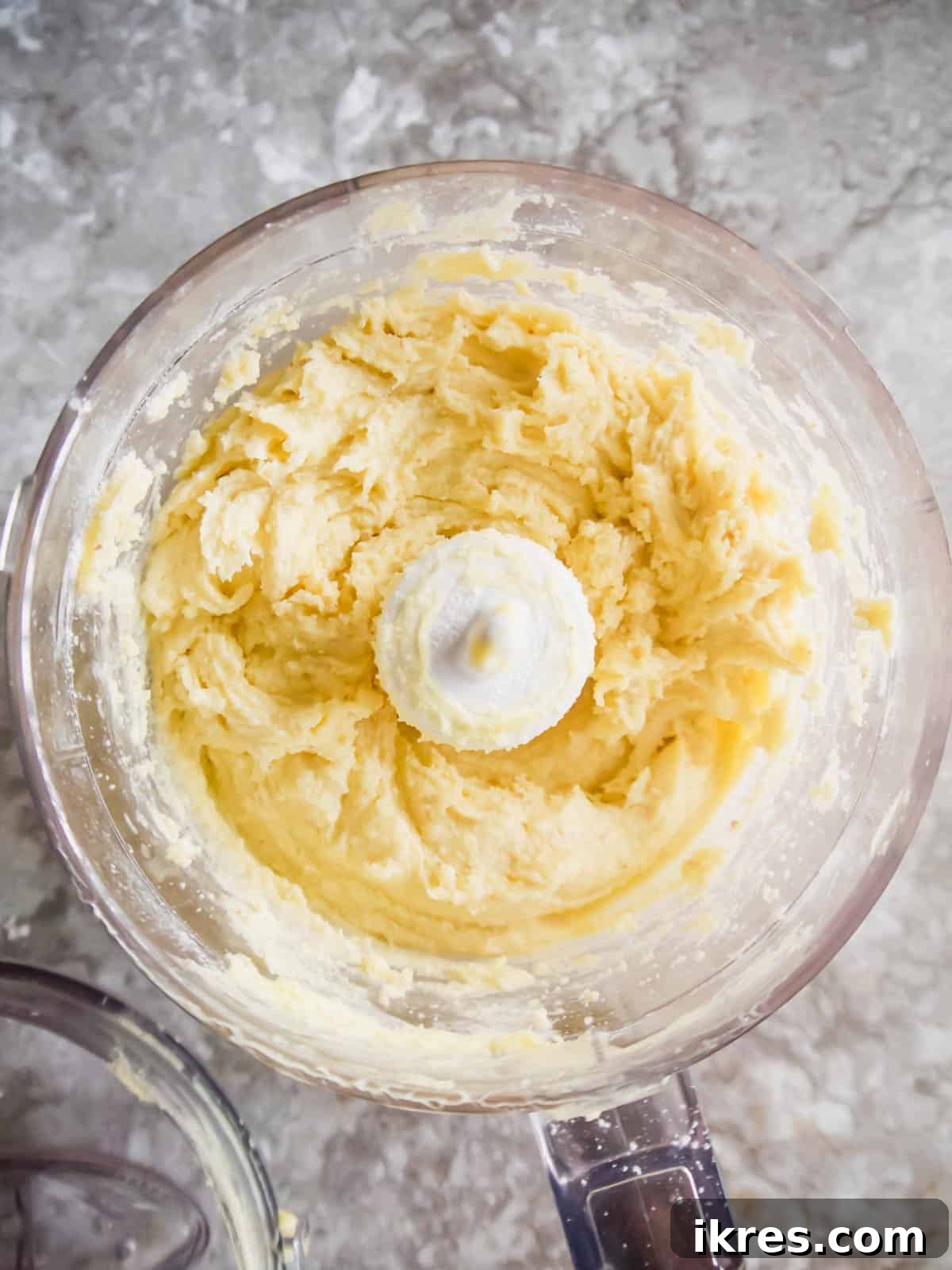 Simple Paleo Pie and Tart Crust Naturally Gluten and Dairy Free 6 Paleo tart crust dough after water and egg have been added to the food processor, looking creamy.