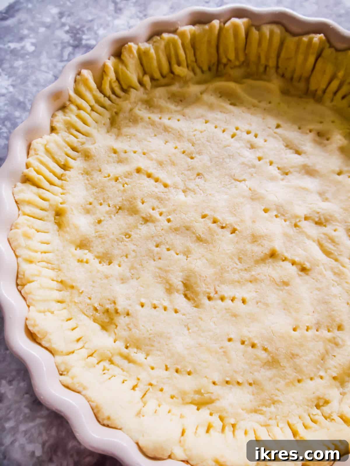 Paleo tart crust pressed into a tart pan, ready for partial baking.
