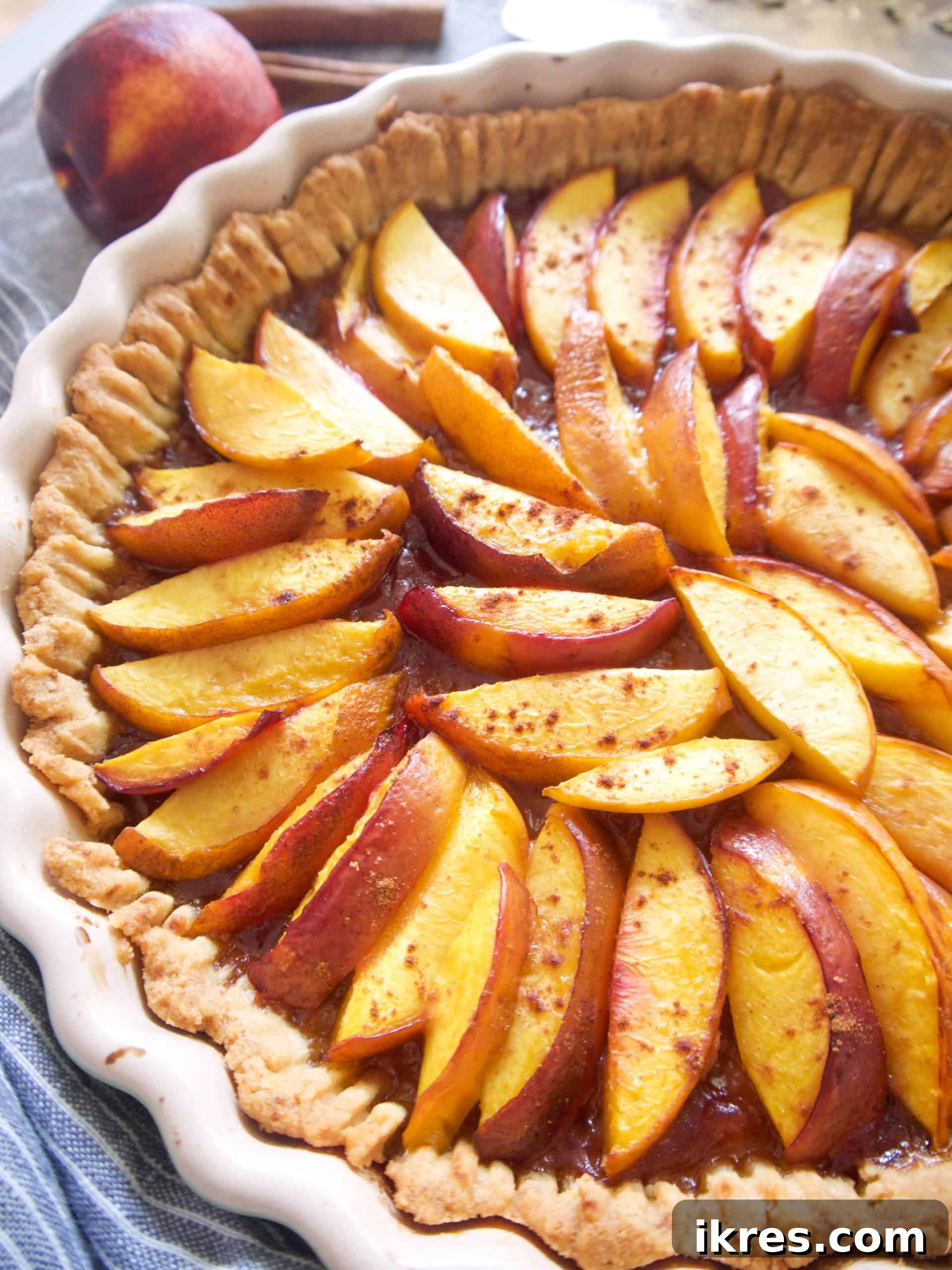 Freshly baked dairy-free nectarine tart, golden and glistening, cooling on a wire rack.