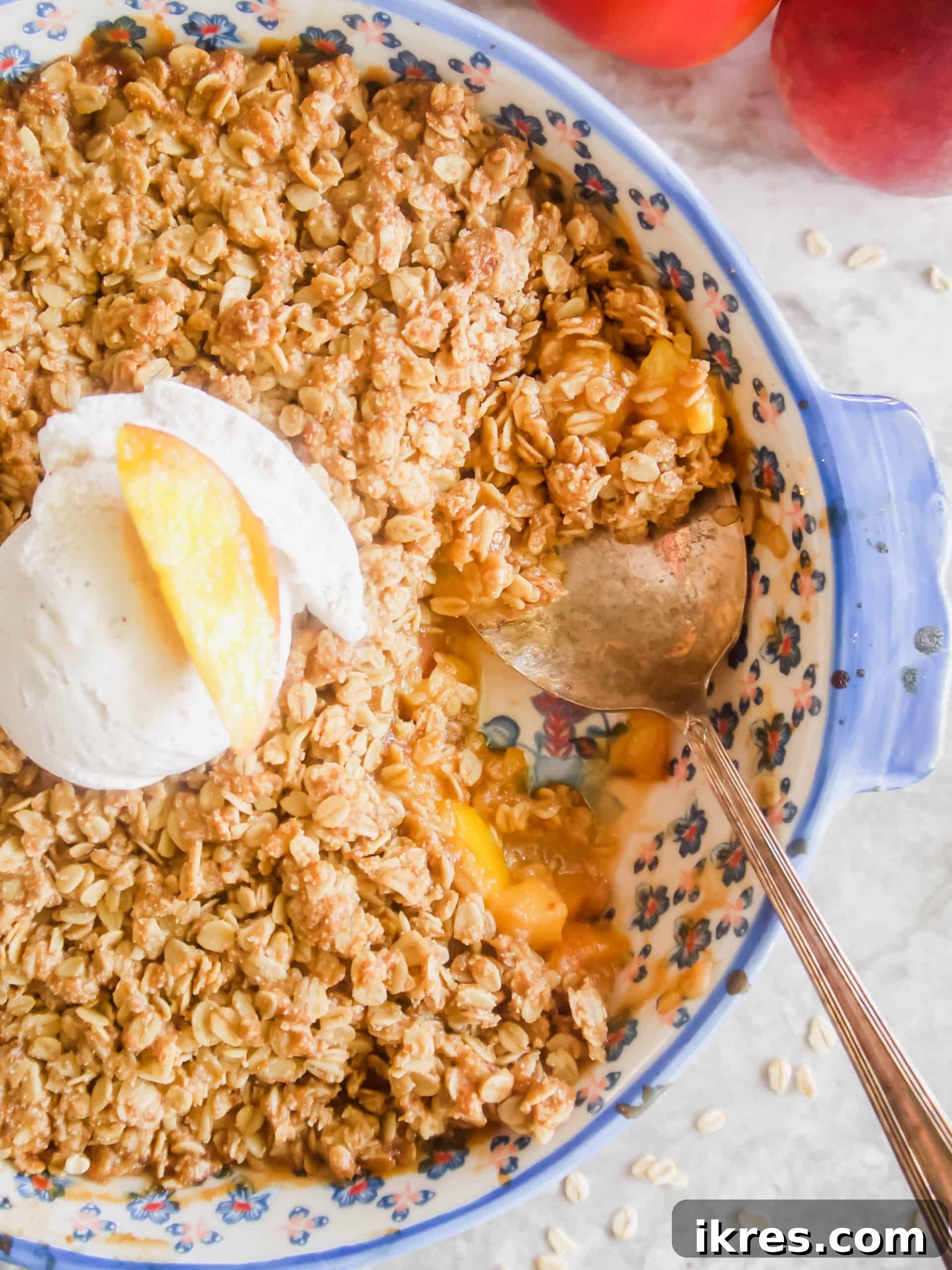 Nectarine Sunshine Crumble Gluten Free Dairy Free 5 Close-up of freshly baked nectarine crisp, with a golden, crumbly topping and bubbling fruit, served in a bowl with melting ice cream.