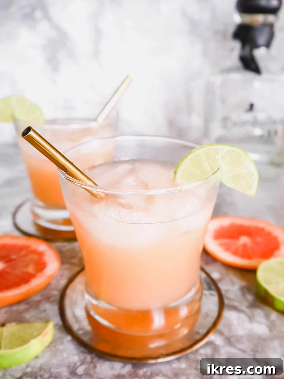 Naturally Sweetened Honey Paloma 5 Two fresh paloma cocktails with straws and lime garnishes, ready to serve.