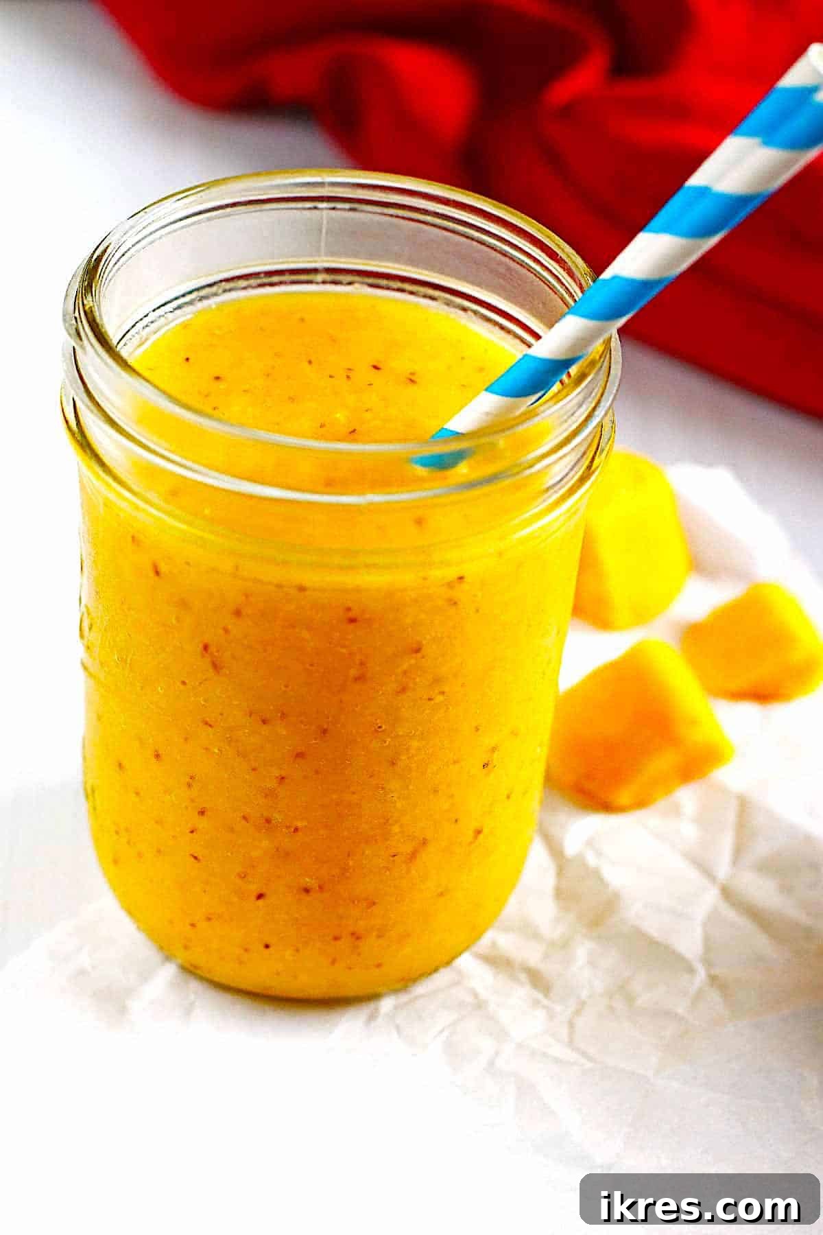 Vibrant Pineapple and Mango Smoothie served in a classic canning jar with a straw, capturing a refreshing tropical vibe.