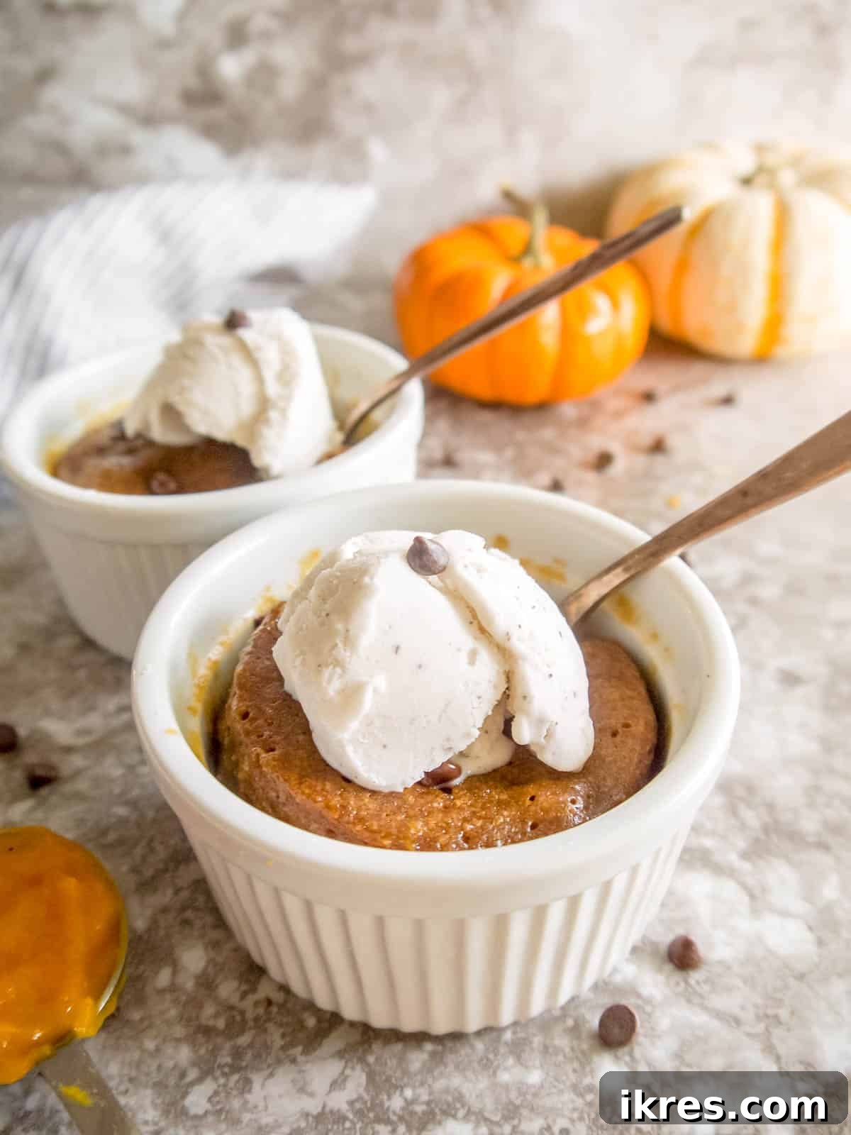 Easy Paleo Pumpkin Spice Mug Cake 10 A finished pumpkin mug cookie topped with a generous scoop of ice cream, ready to be enjoyed.