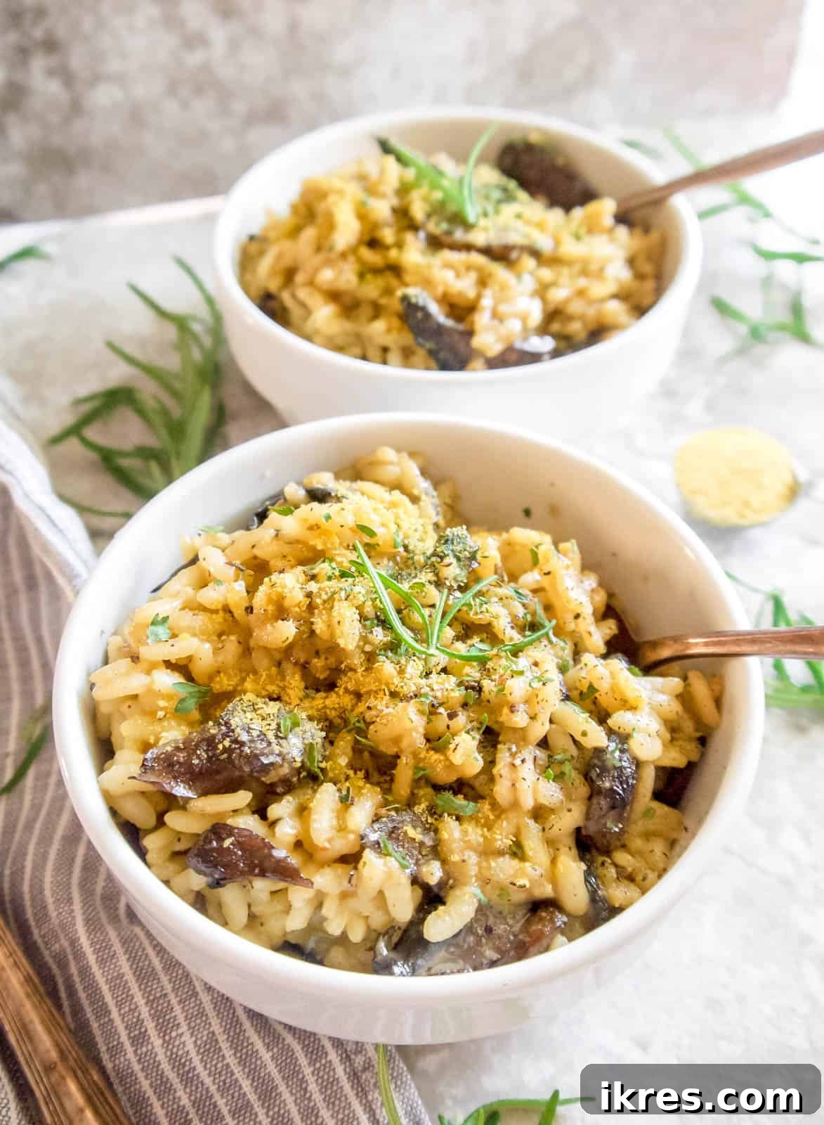 A close-up of Dairy-Free Mushroom Risotto in a bowl, garnished with a generous sprinkle of nutritional yeast.