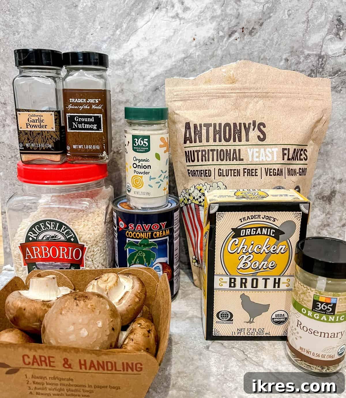 A curated selection of fresh ingredients laid out on a table, including Arborio rice, spices, coconut cream, and baby bella mushrooms, ready for making dairy-free mushroom risotto.