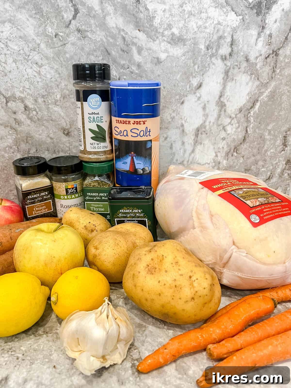 Golden Roast Chicken with Apples and Potatoes Dairy Free 4 Arrangement of fresh ingredients including a whole chicken, various potatoes, apples, lemons, garlic, and herbs, ready for the roast.