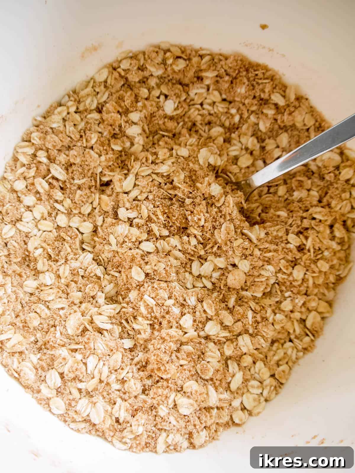 A bowl filled with the almond and oat crisp topping mixture, perfectly combined and ready to be sprinkled.