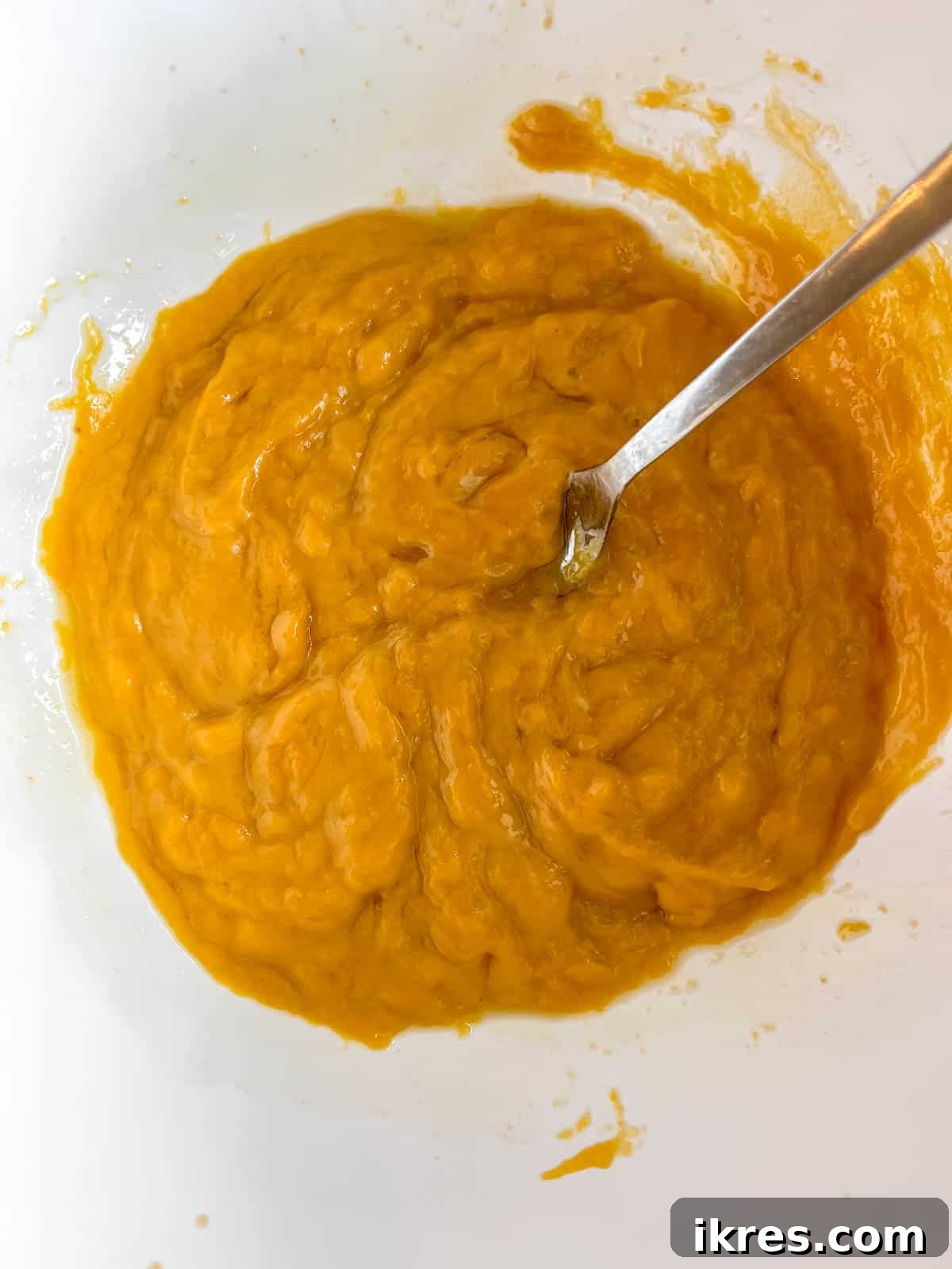 Wet ingredients for paleo pumpkin muffins mixed in a bowl.