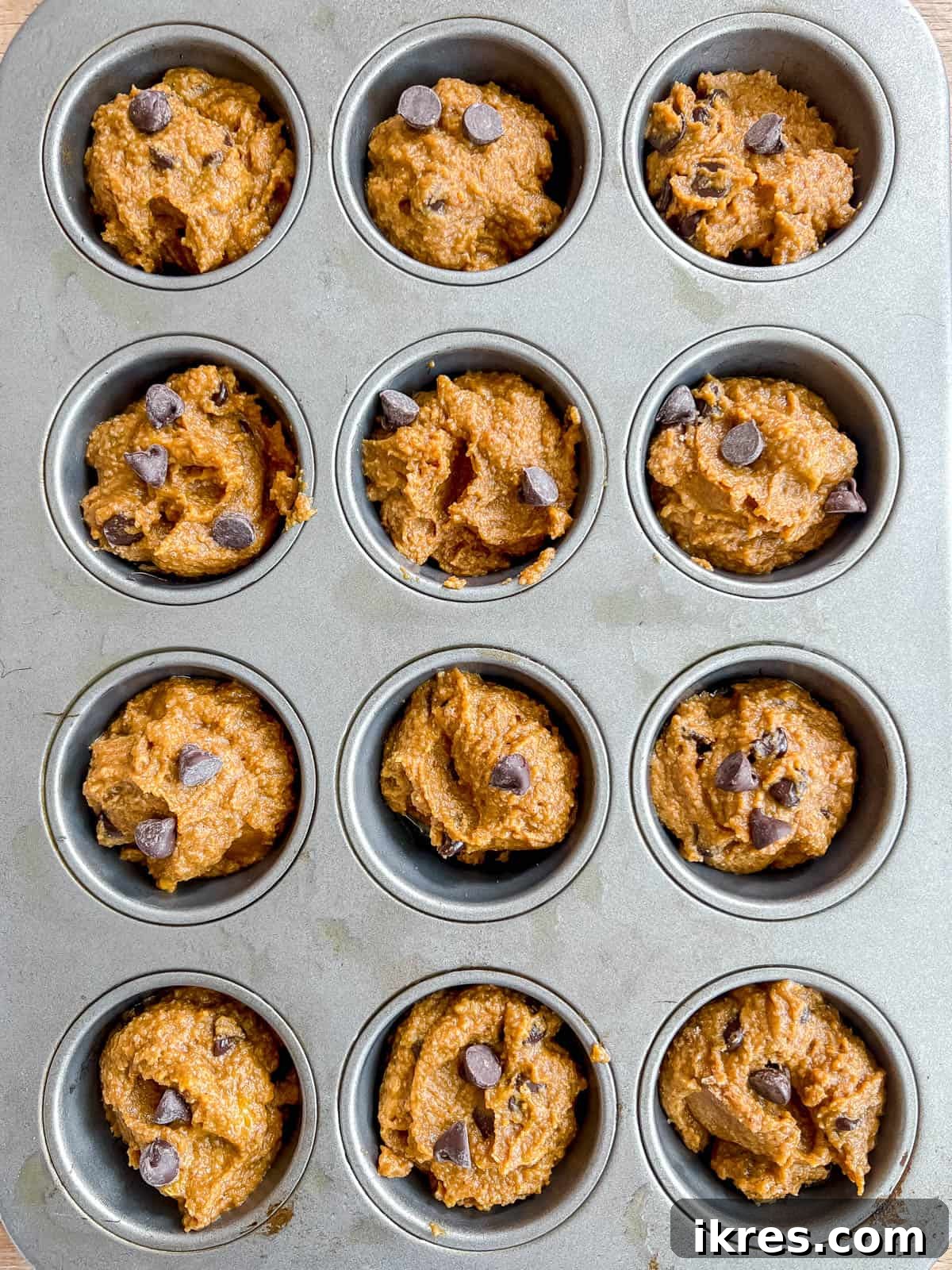 Paleo pumpkin muffins batter poured into muffin tins before baking.