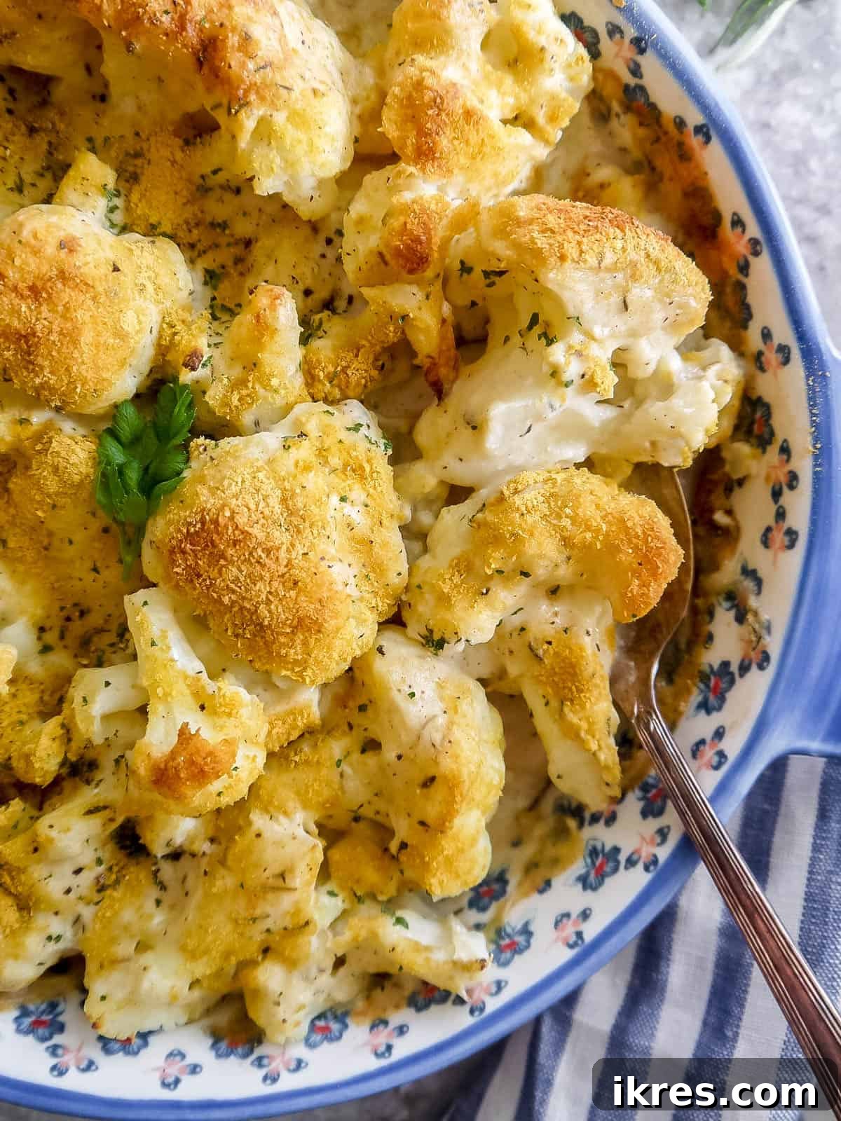 Vegan Paleo Dairy Free Cauliflower Bake 3 Close-up of freshly baked Vegan cauliflower gratin in a dish, showing the golden top and creamy texture, with a serving spoon.