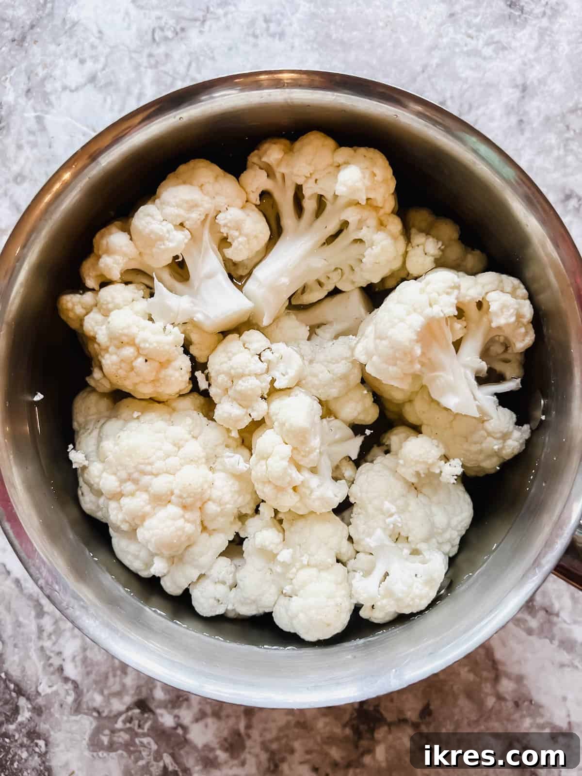 Vegan Paleo Dairy Free Cauliflower Bake 5 Cauliflower florets arranged neatly in a pot, ready to be boiled to tender perfection before being incorporated into the casserole.