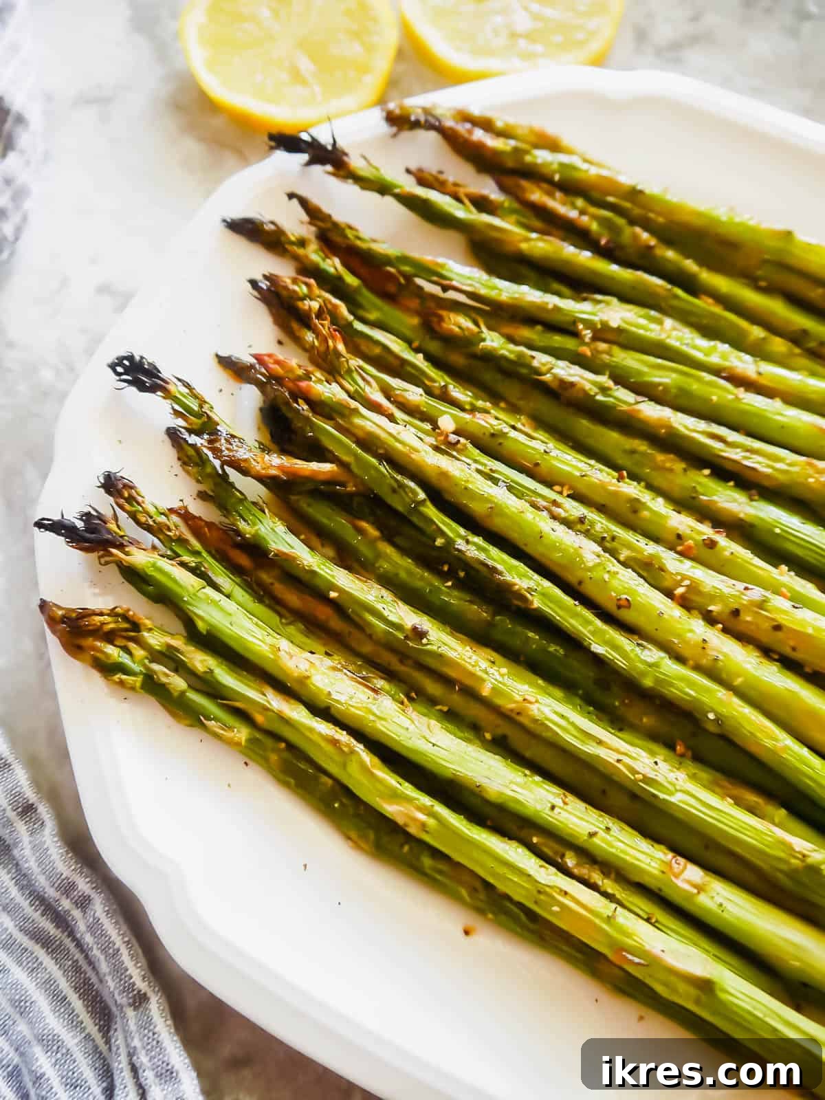 Easy Broiled Lemon Asparagus, a simple, flavorful, and healthy Paleo veggie side dish for any meal.