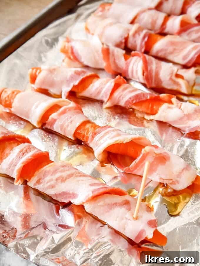 Step-by-step: Fully wrapped carrot on a baking sheet.