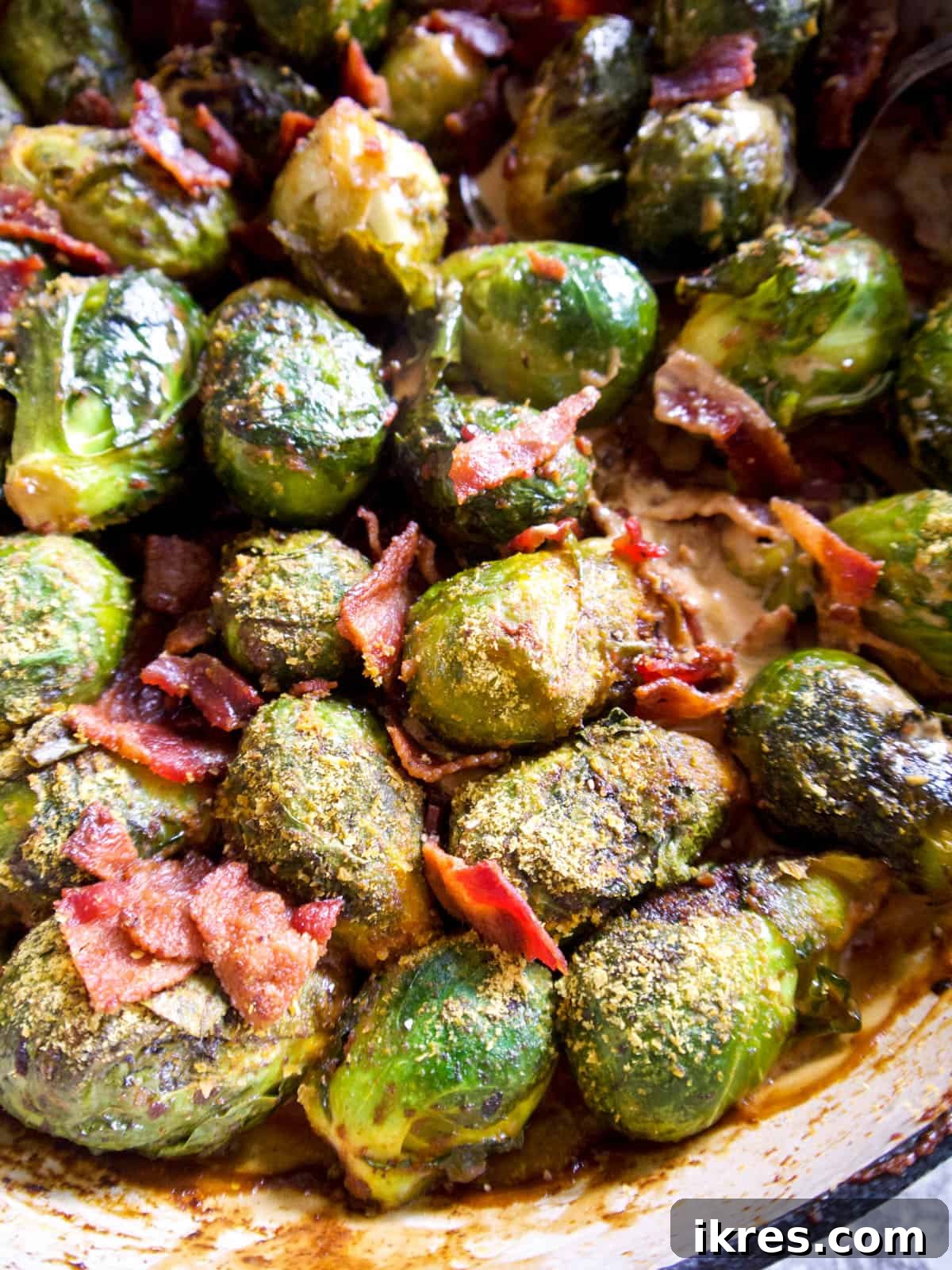 Wholesome Brussels Sprouts Bake Paleo Whole30 3 A close-up of a bubbling Brussels sprout casserole with crispy bacon pieces, fresh out of the oven.