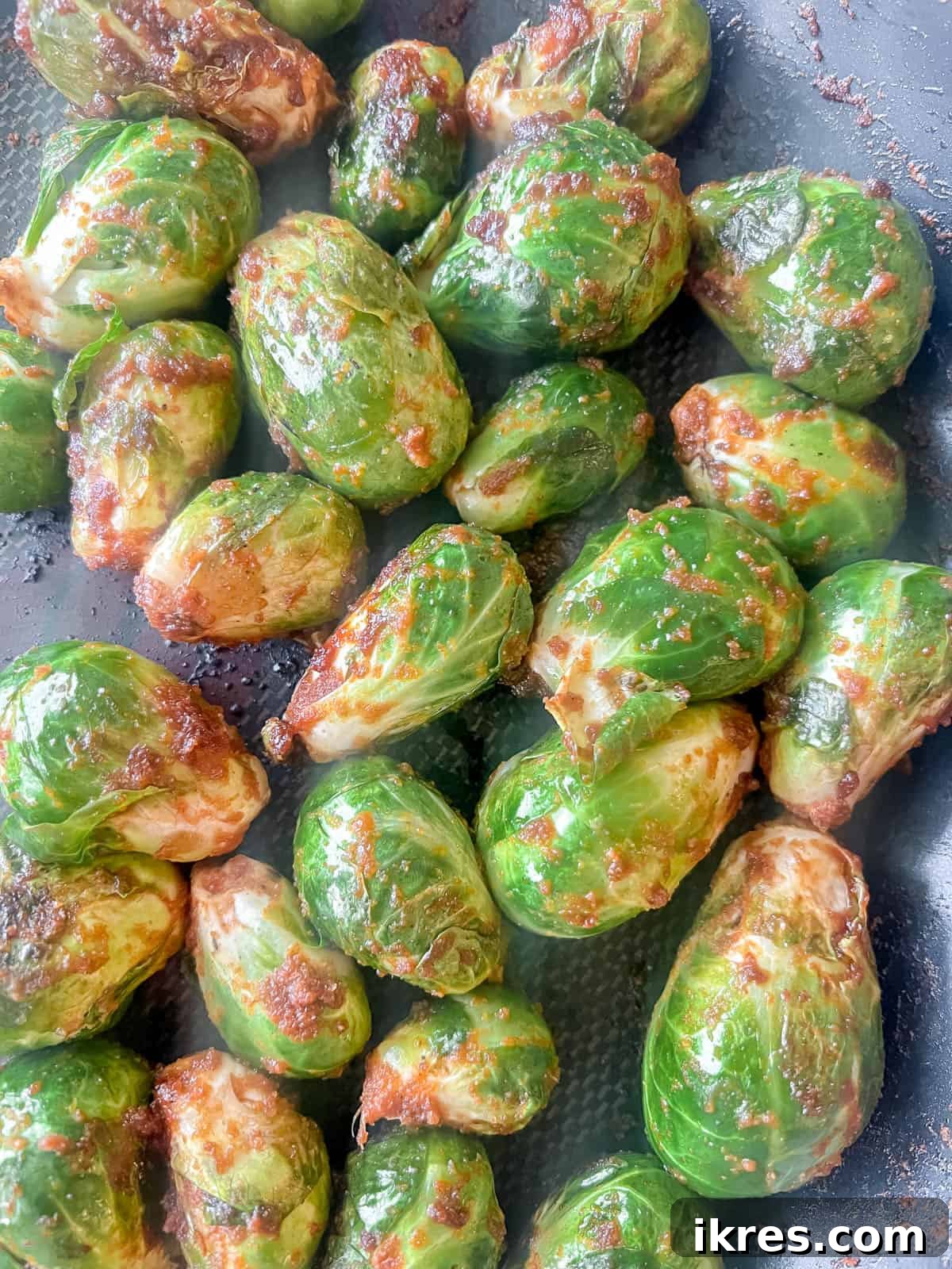 Wholesome Brussels Sprouts Bake Paleo Whole30 7 Brussels sprouts gently cooking in a pan, lightly browned and beginning to tenderize, showing the addition of water for steaming.