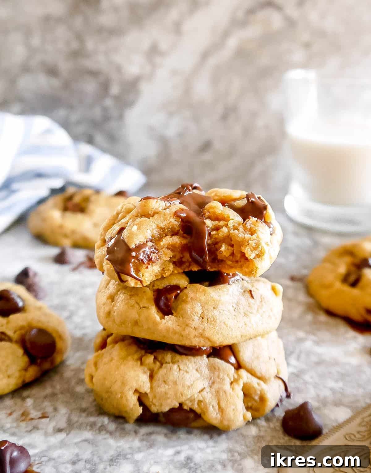 Plant Based Olive Oil Chocolate Chip Cookies 9 Three chocolate chip cookies stacked on each other with top cookie with bite taken out of it.