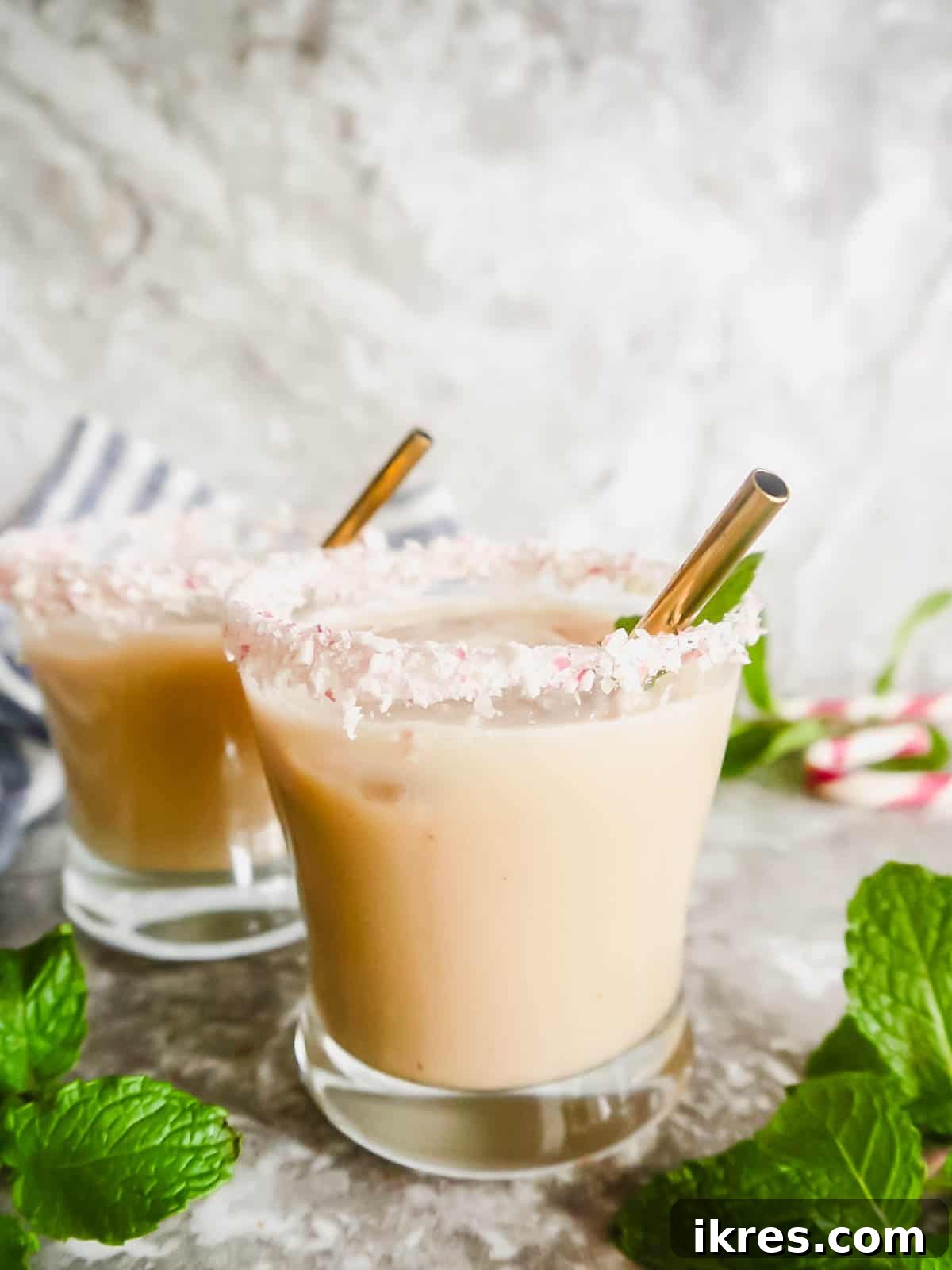 Frosted Peppermint White Russian 2 Two glasses of creamy Dairy-Free Peppermint White Russian cocktails, garnished with candy canes, ready for festive enjoyment.