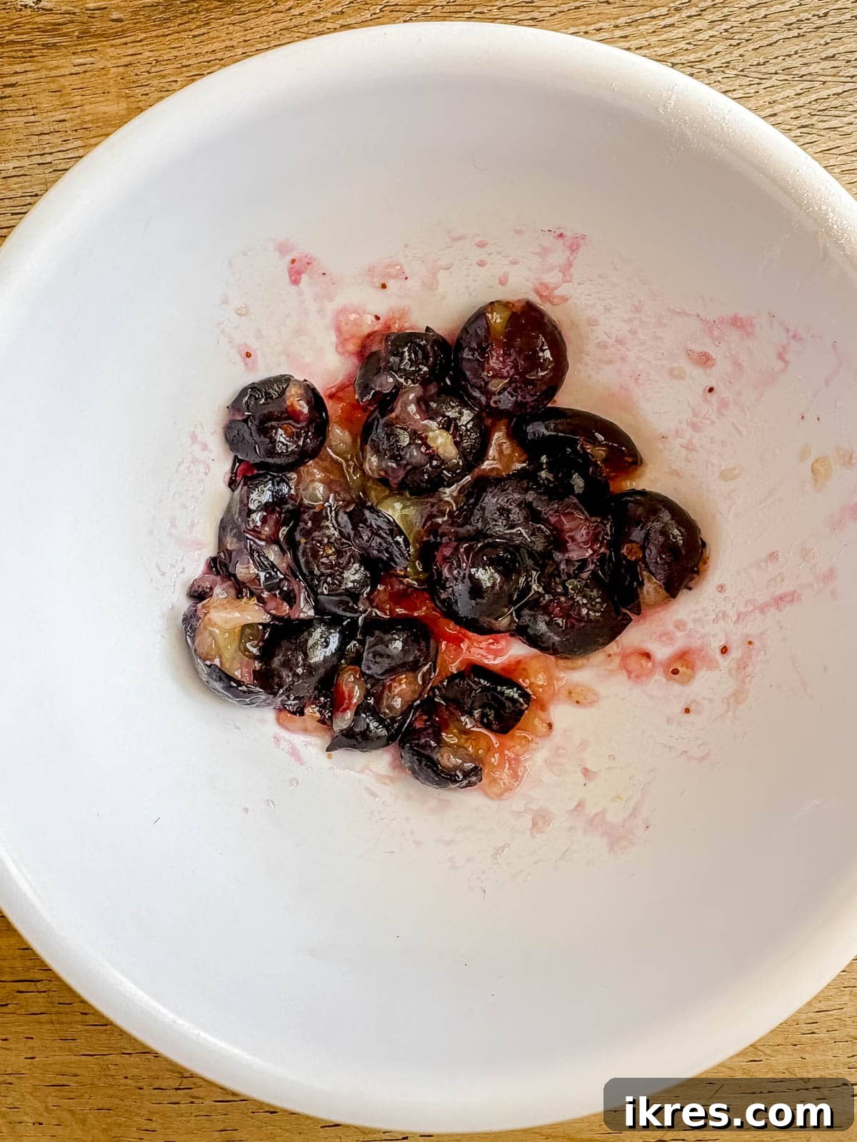 Naturally Dairy-Free Olive Oil Blueberry Muffins 7 A small bowl of mashed blueberries.