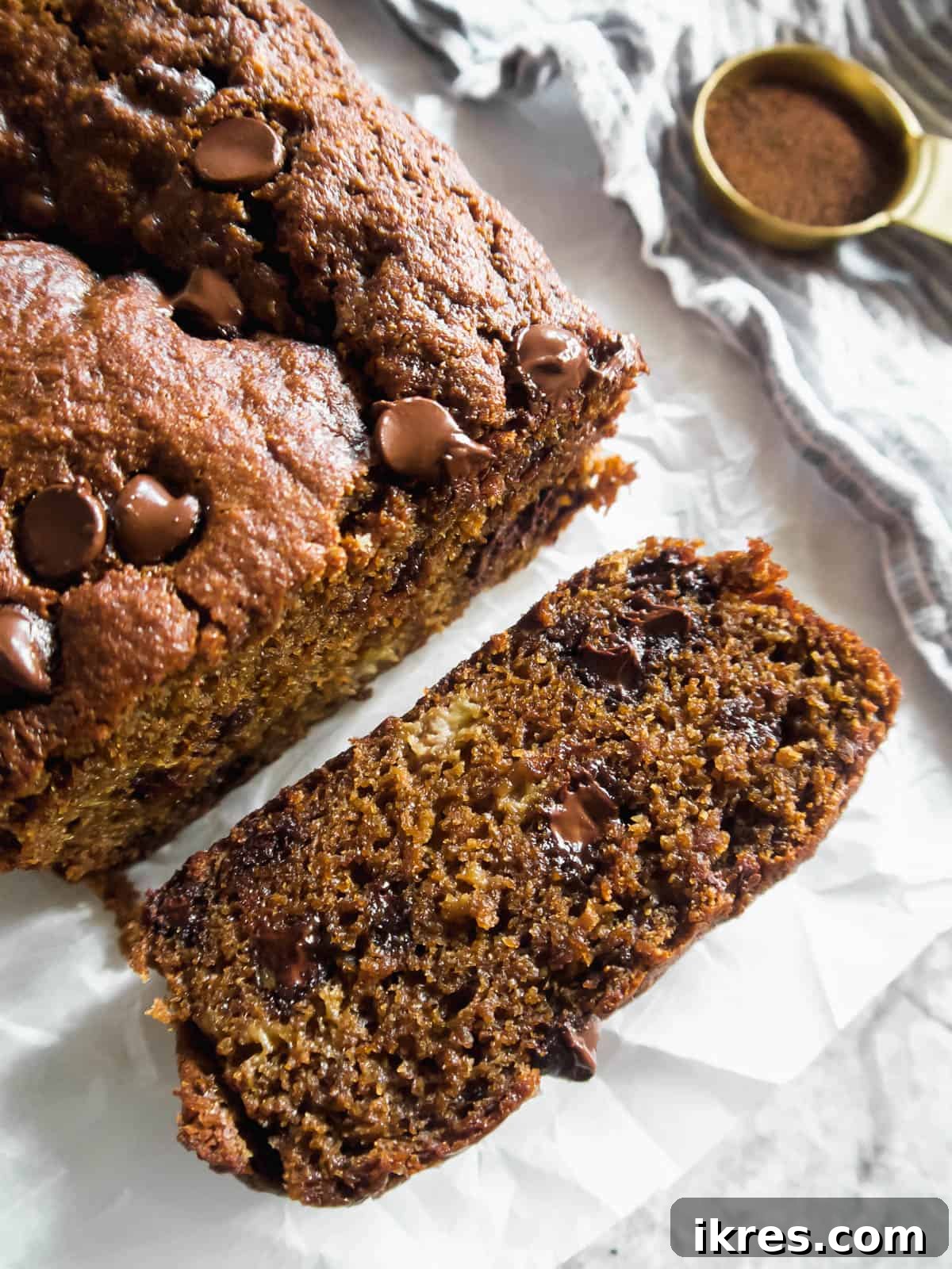 Decadent Espresso Chocolate Chip Banana Bread Paleo Gluten Free Dairy Free 2 A perfectly sliced piece of espresso banana bread with visible chocolate chips, resting on parchment paper.
