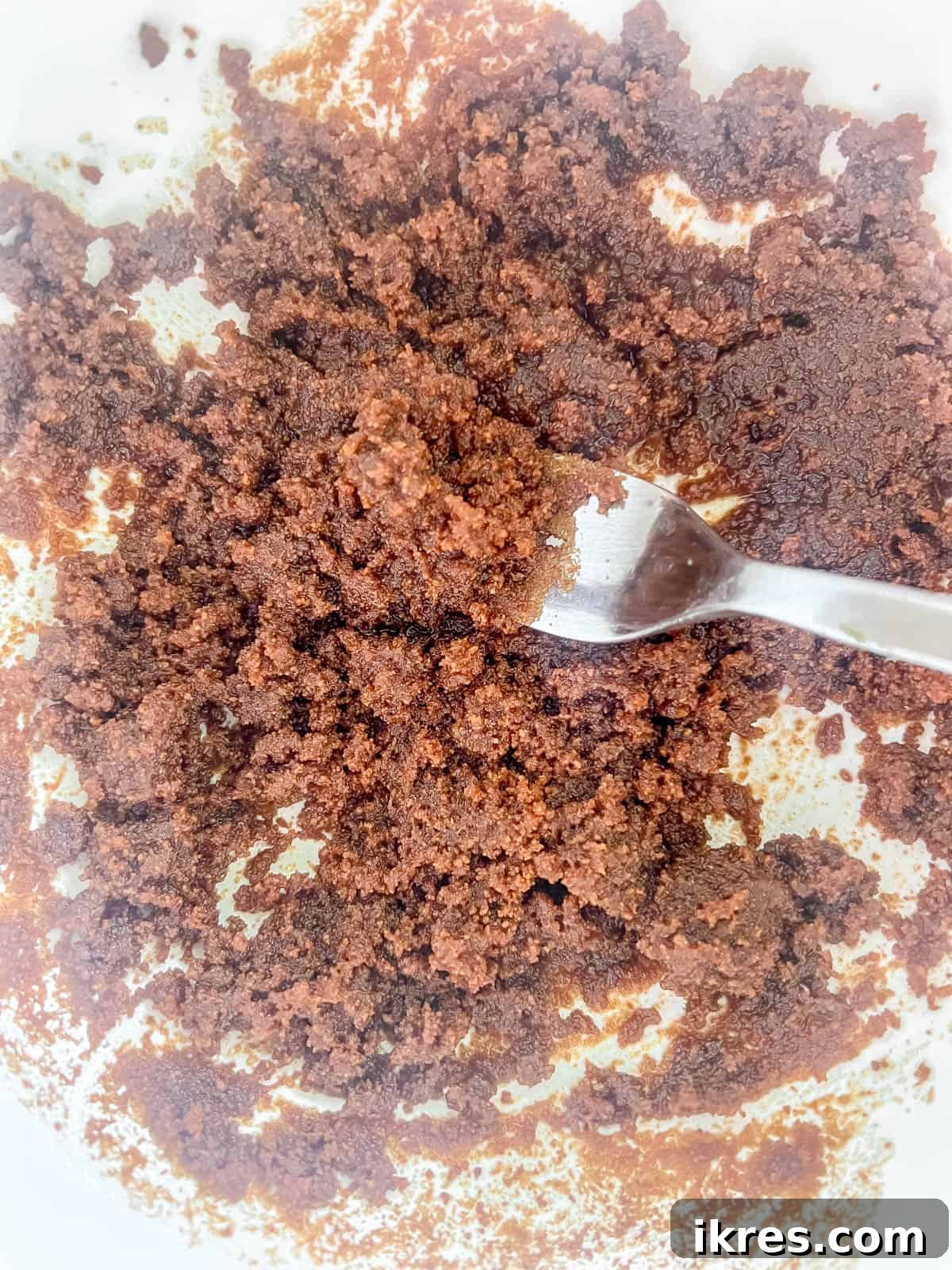 Decadent Espresso Chocolate Chip Banana Bread Paleo Gluten Free Dairy Free 5 Coconut sugar being mixed with olive oil in a bowl until thoroughly combined.