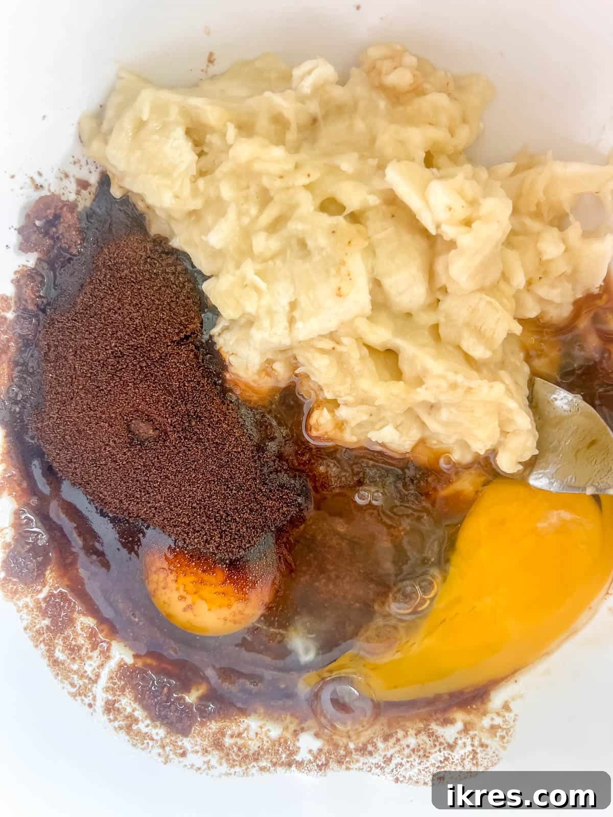 Decadent Espresso Chocolate Chip Banana Bread Paleo Gluten Free Dairy Free 6 Wet ingredients for banana bread, including mashed banana, eggs, and espresso, combined in a bowl.