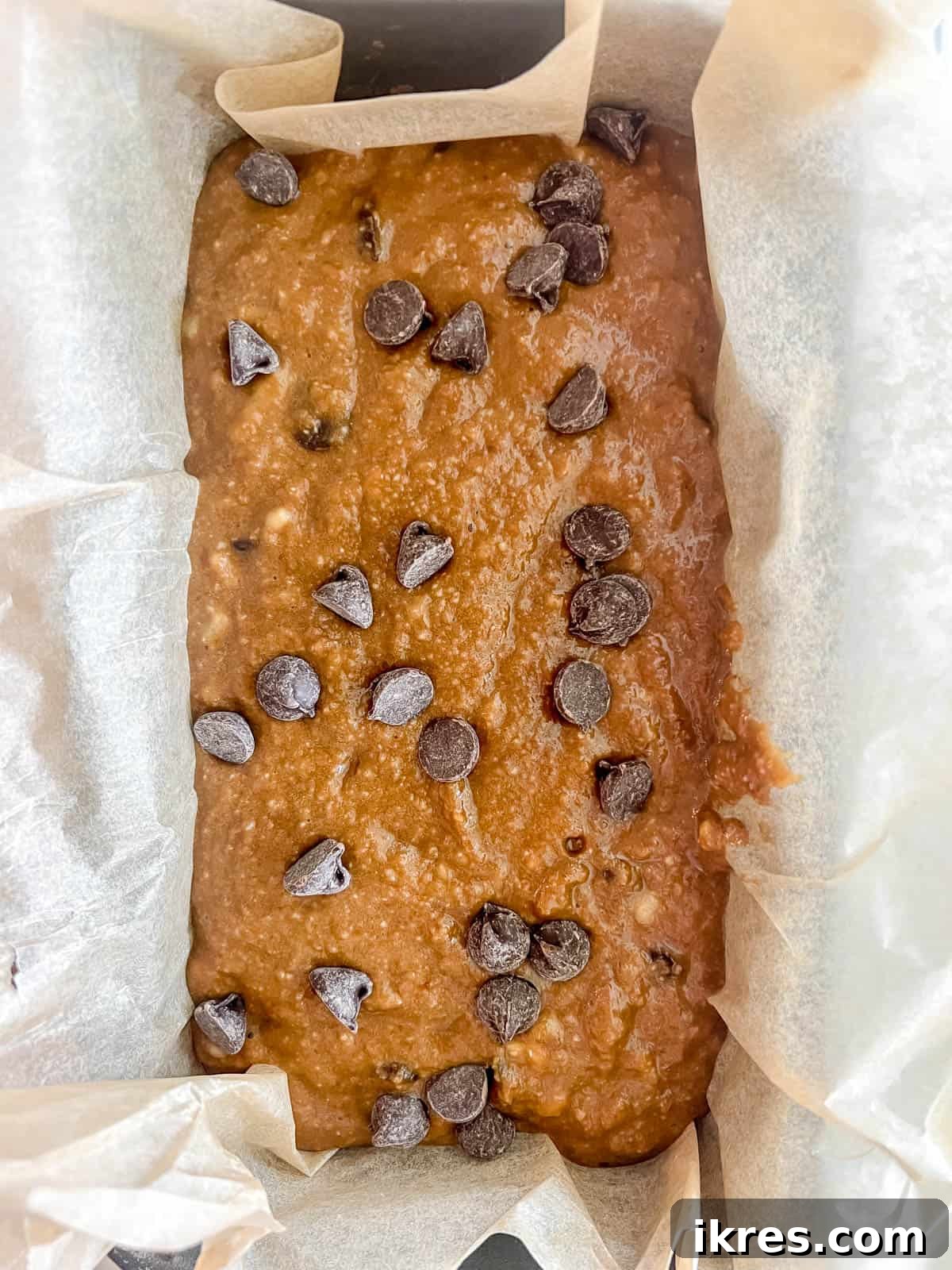 Decadent Espresso Chocolate Chip Banana Bread Paleo Gluten Free Dairy Free 9 Espresso banana bread batter poured into a loaf tin and topped with extra chocolate chips, ready for the oven.