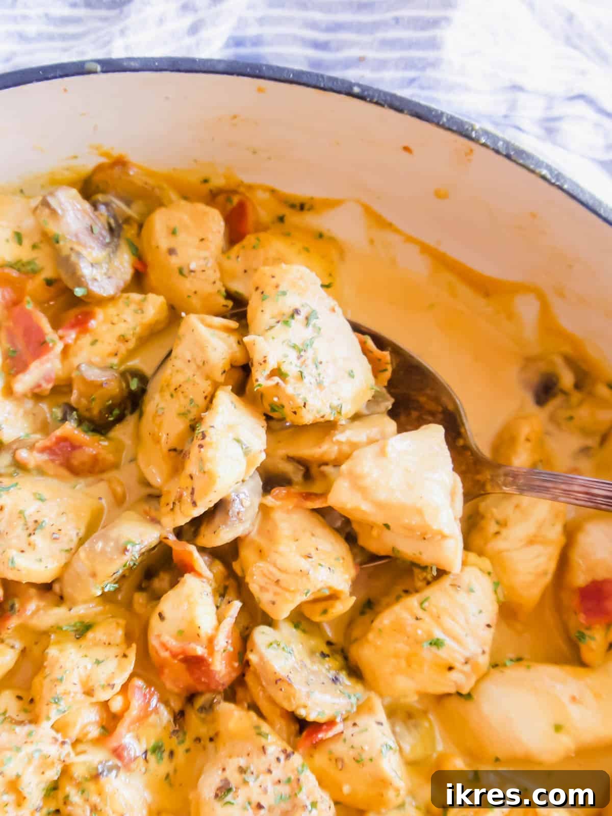 Chicken, bacon, and mushrooms simmering in a flavorful sauce before adding coconut cream.
