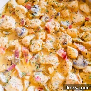 Creamy Dairy-Free Bacon and Mushroom Chicken in a pan, plated for serving.