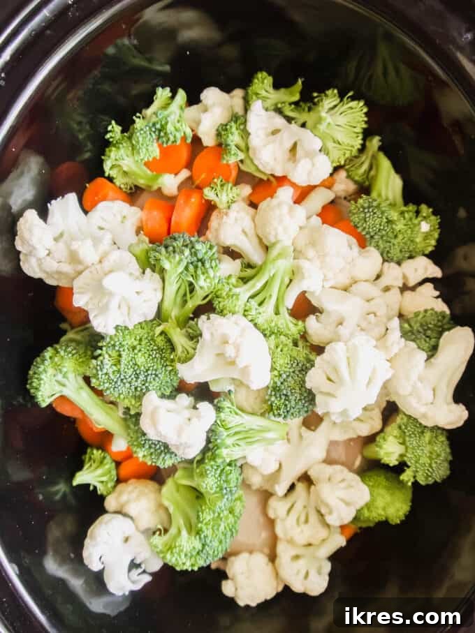 Comforting Slow Cooker Chicken Pot Pie Soup Whole30 Paleo Dairy Free 4 A mix of diced carrots, gold potatoes, and cauliflower florets added over the chicken in the slow cooker.