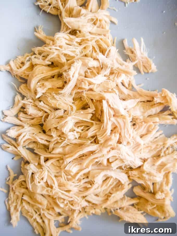 Comforting Slow Cooker Chicken Pot Pie Soup Whole30 Paleo Dairy Free 6 Cooked chicken breasts removed from the slow cooker, placed on a cutting board, ready for shredding.