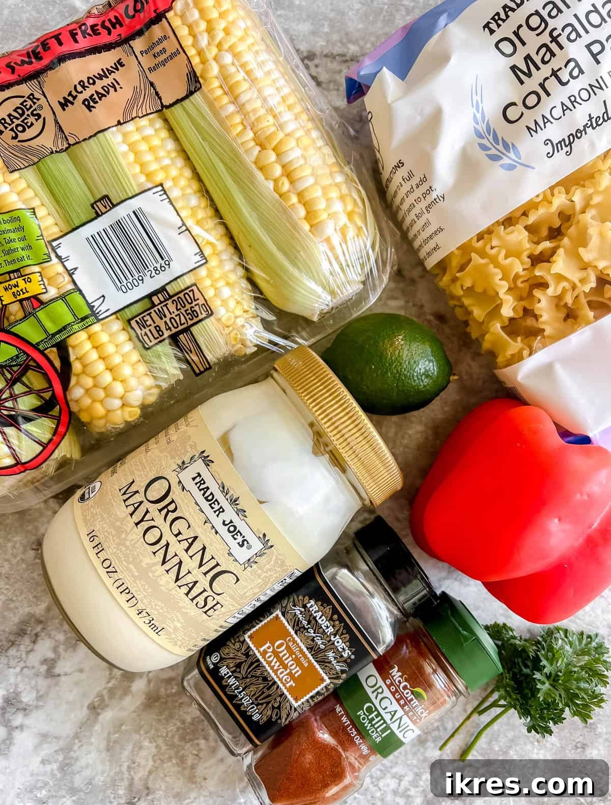 Ingredients needed to make Mexican street corn salad, including corn, mayo, lime, and fresh vegetables.