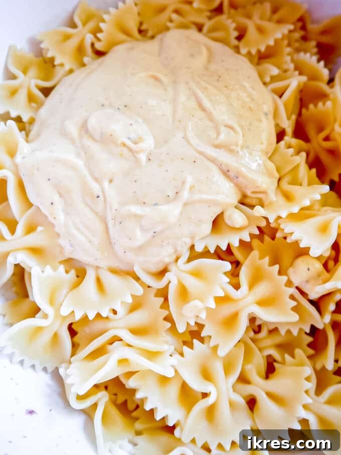 The sauce on top of the pasta, ready to be mixed.