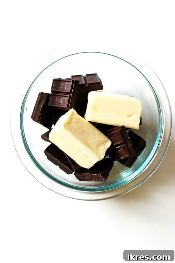 Ultimate Homemade Brownies 4 Unsalted butter and broken pieces of semi-sweet baking chocolate in a clear microwave-safe bowl, ready for melting.
