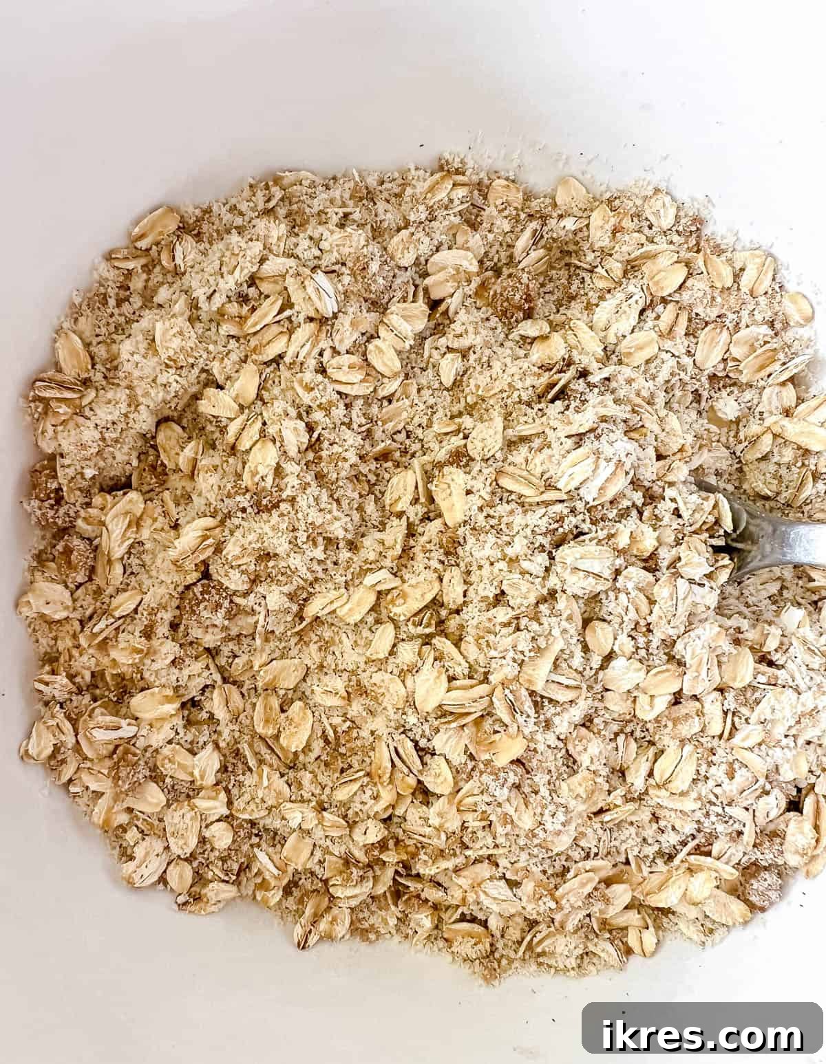 Wholesome Gluten Free Dairy Free Almond Oatmeal Treats 5 Dry ingredients for almond oatmeal cookies, including oats, almond flour, and spices, mixed together in a large bowl.