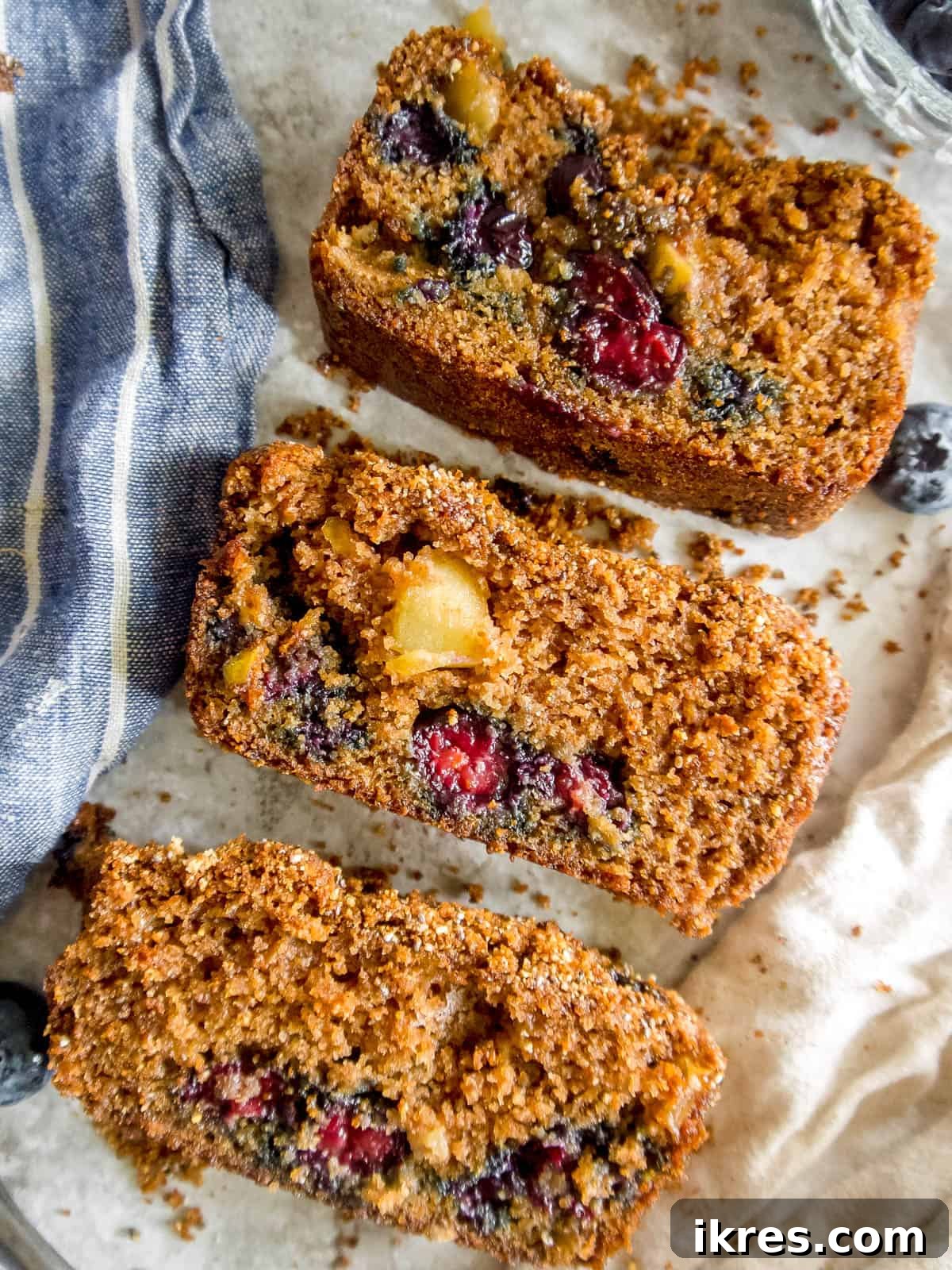 Three perfectly sliced pieces of almond flour blueberry bread displayed in a row.