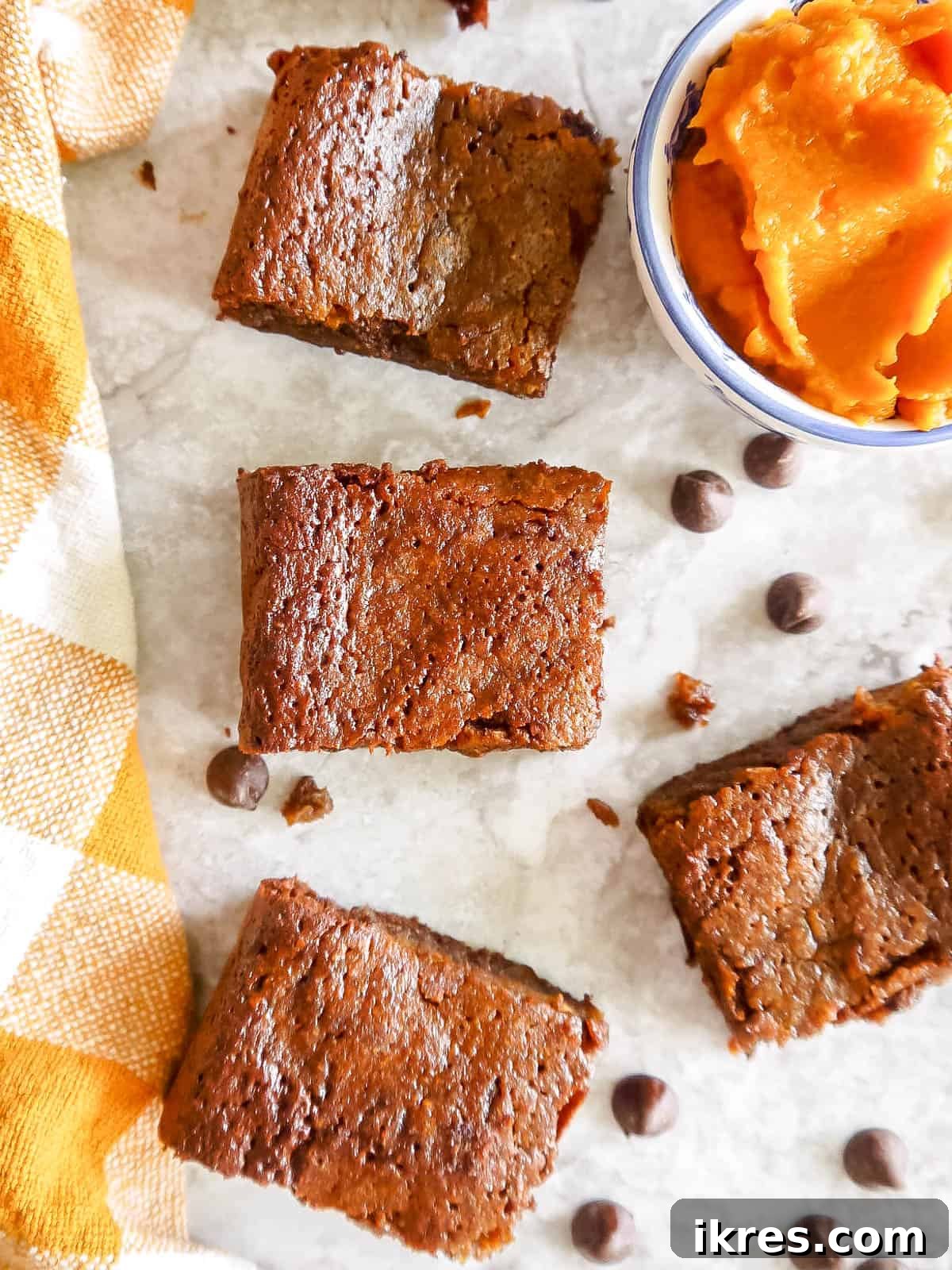 Healthy Pumpkin Brownies cut into neat squares, surrounded by dairy-free chocolate chips.