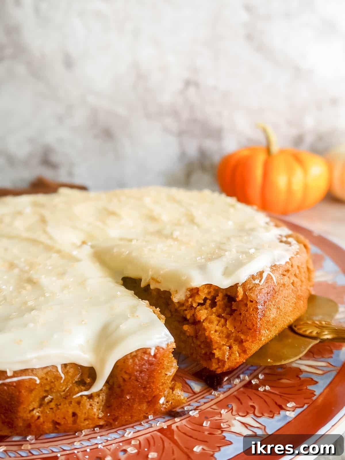 Artisanal Pumpkin Olive Oil Cake 13 A delicious slice of almond flour pumpkin cake being presented on a plate, highlighting its perfect texture and tempting frosting, ready for enjoyment.