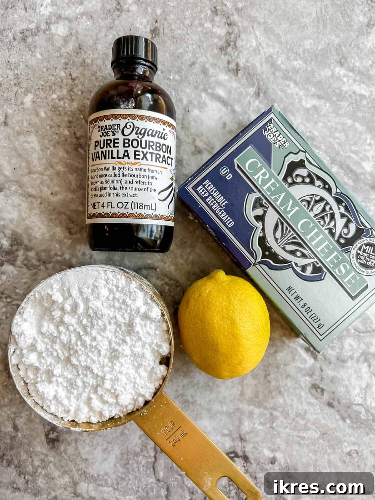 Artisanal Pumpkin Olive Oil Cake 5 Ingredients specifically for the healthy pumpkin cake's cream cheese frosting are arranged, including cream cheese, powdered sugar, vanilla extract, and lemon juice.