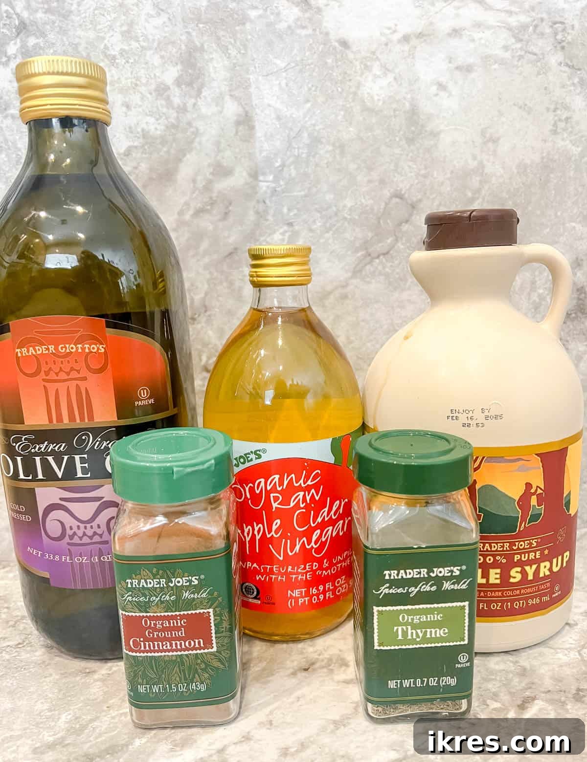 The simple yet flavorful ingredients for the homemade maple vinaigrette, including olive oil, maple syrup, and apple cider vinegar, arranged in small bowls.