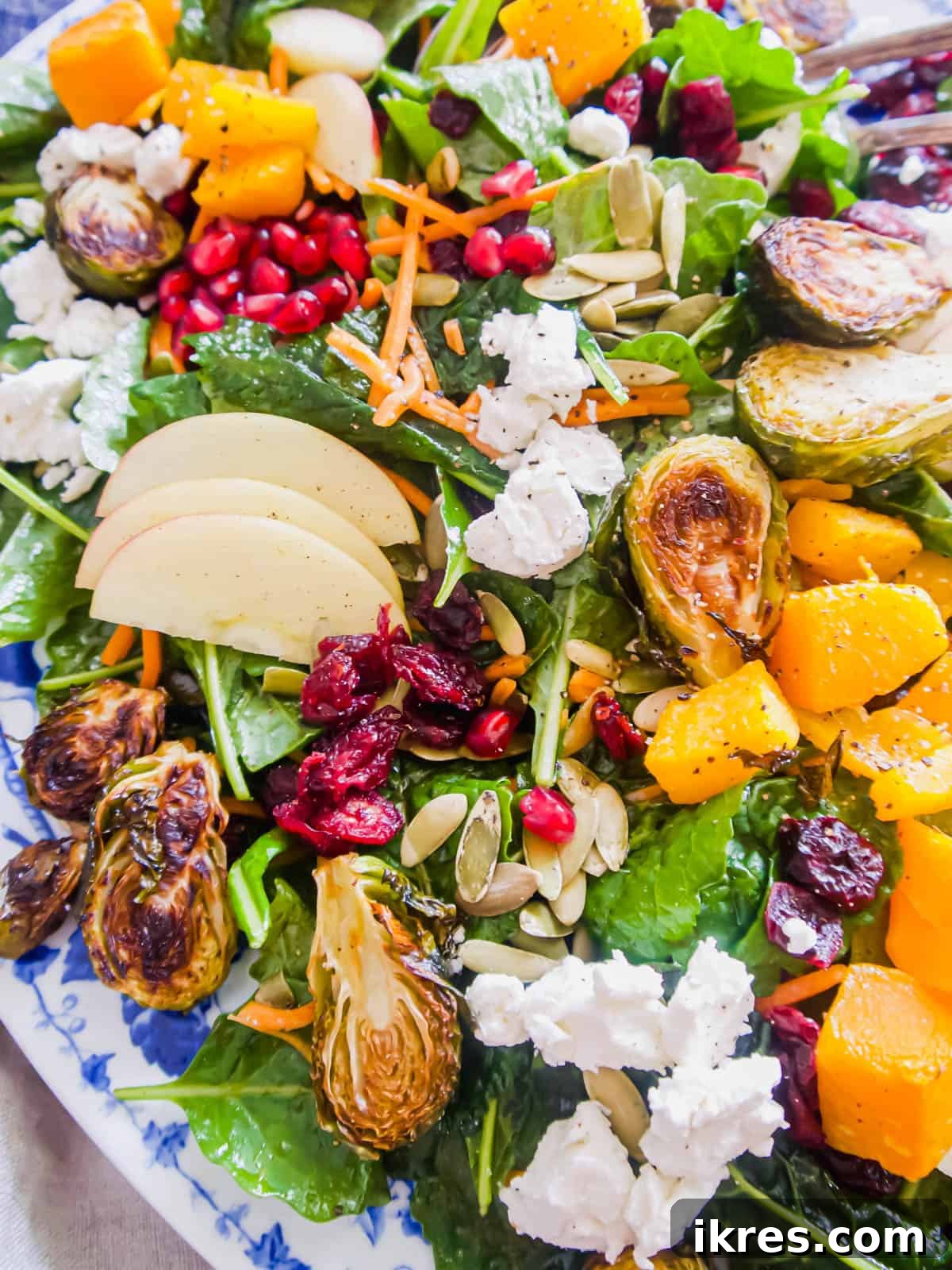 A generous autumn harvest salad served in a large, rustic bowl, showcasing all its colorful and textured ingredients.