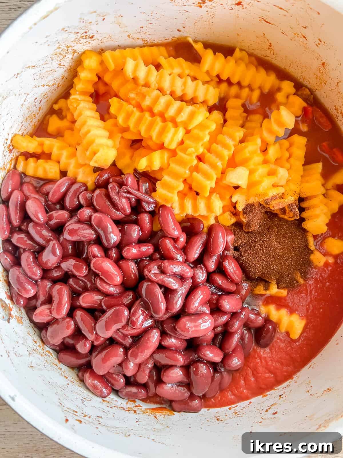 Hearty Turkey Chili with Butternut Squash and Black Beans 7 A mix of black beans, kidney beans, and cubed butternut squash added to the pot with the browned turkey and spices, preparing for simmering.