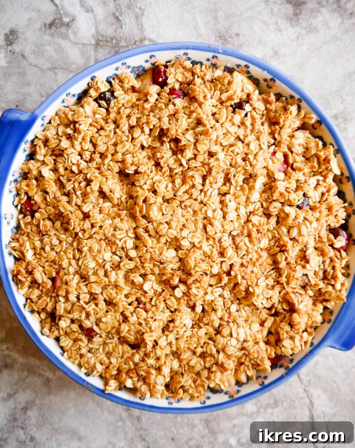 Spiced Pear Cranberry Crisp 7 Gluten-free Pear Cranberry Oatmeal Crisp ready for baking, with topping spread over fruit.
