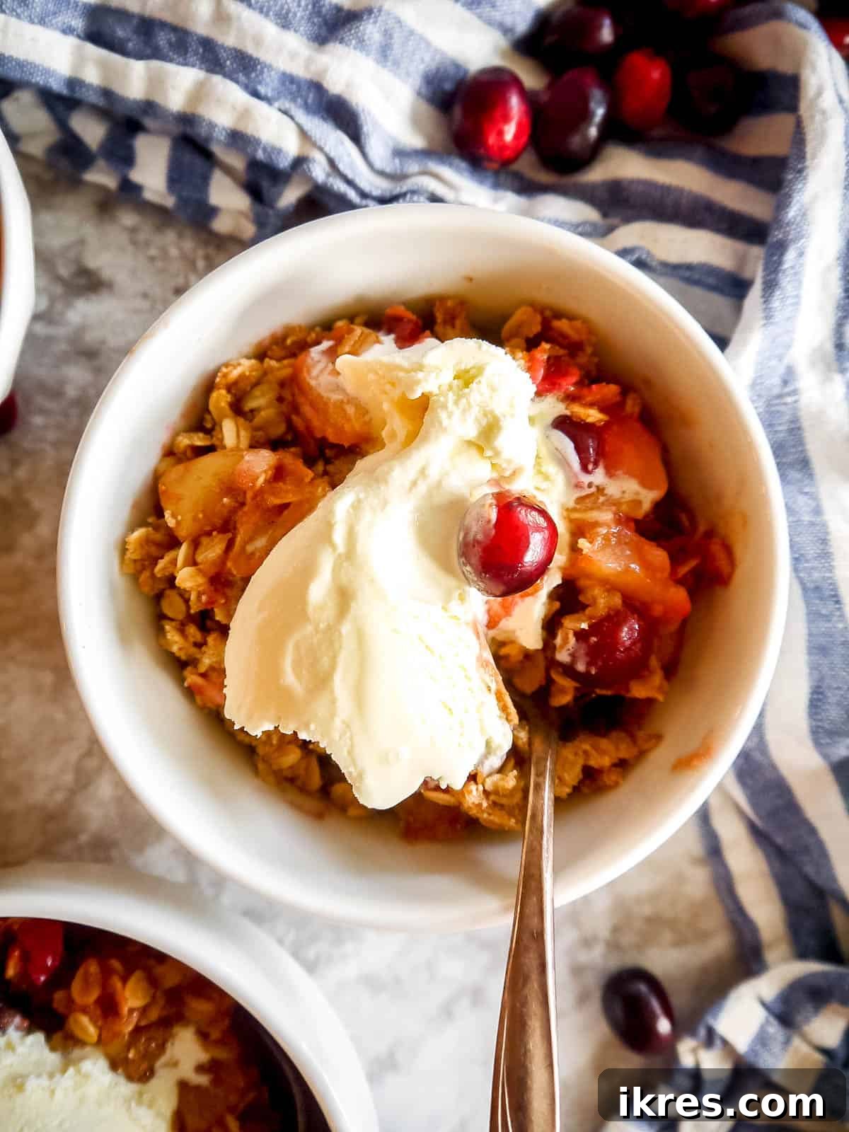 Spiced Pear Cranberry Crisp 10 Gluten-free Pear Cranberry Oatmeal Crisp in a bowl with a scoop of dairy-free ice cream.
