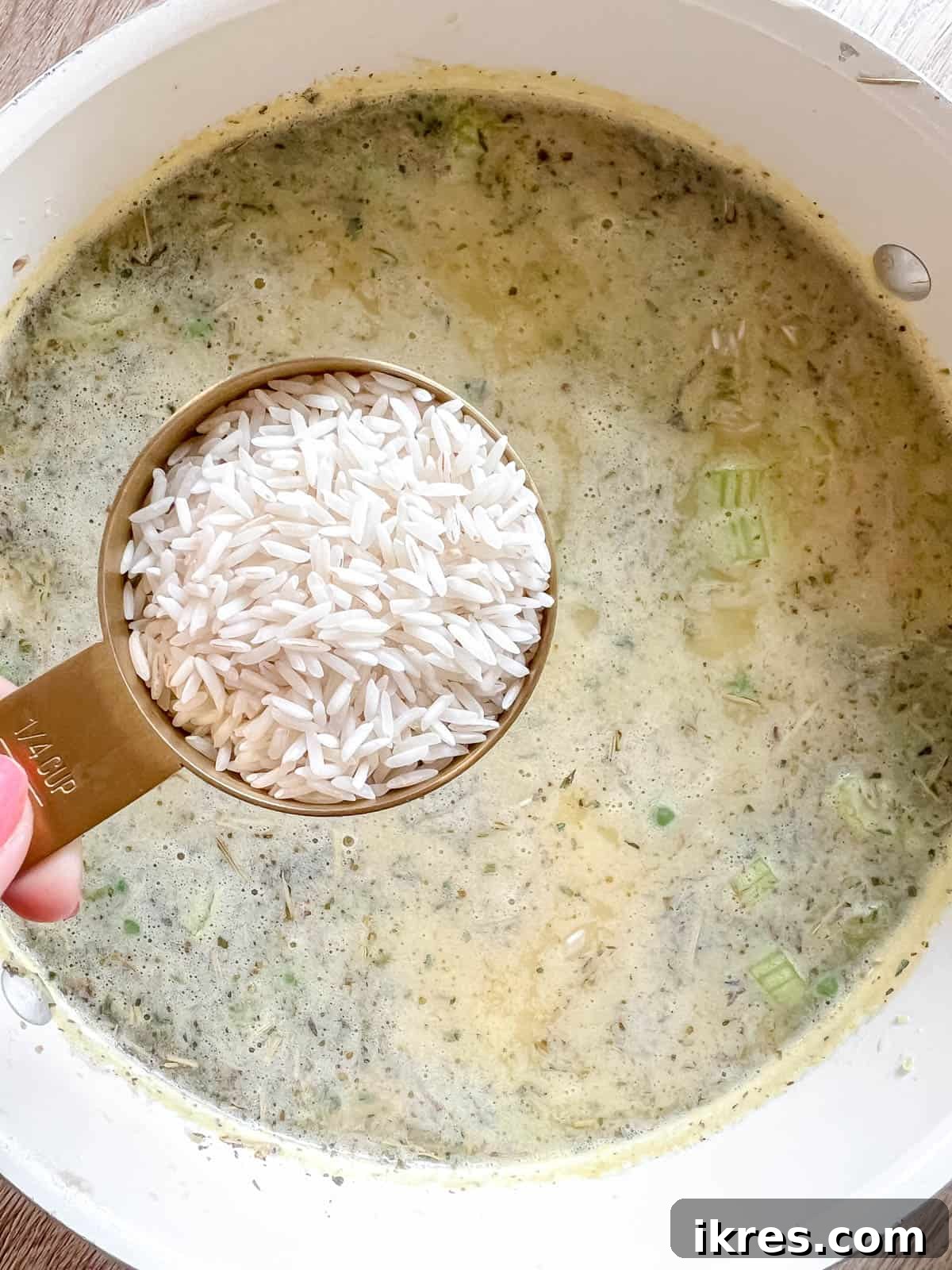 Adding white rice to the simmering turkey and vegetable soup.