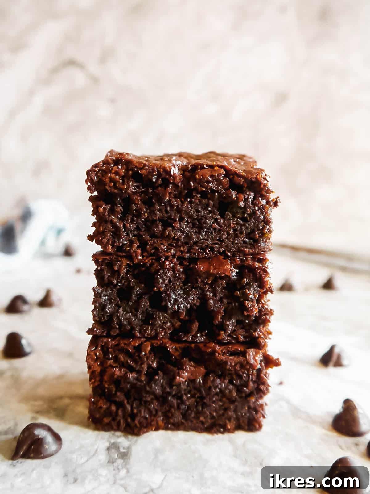 Deliciously Wholesome Almond Flour Brownies 2 A stack of three fudgy healthy almond flour brownies, showcasing their rich, dark chocolate interior and slightly crinkled top.