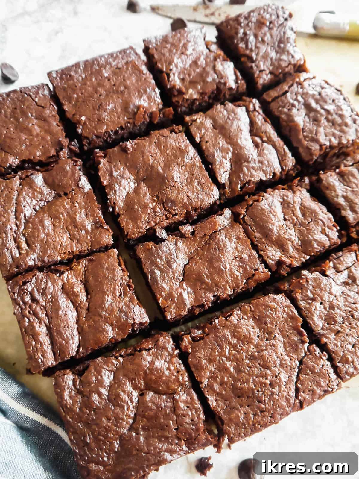 Deliciously Wholesome Almond Flour Brownies 12 Freshly baked almond flour brownies, golden and crinkled on top, cut into neat squares within the baking pan.