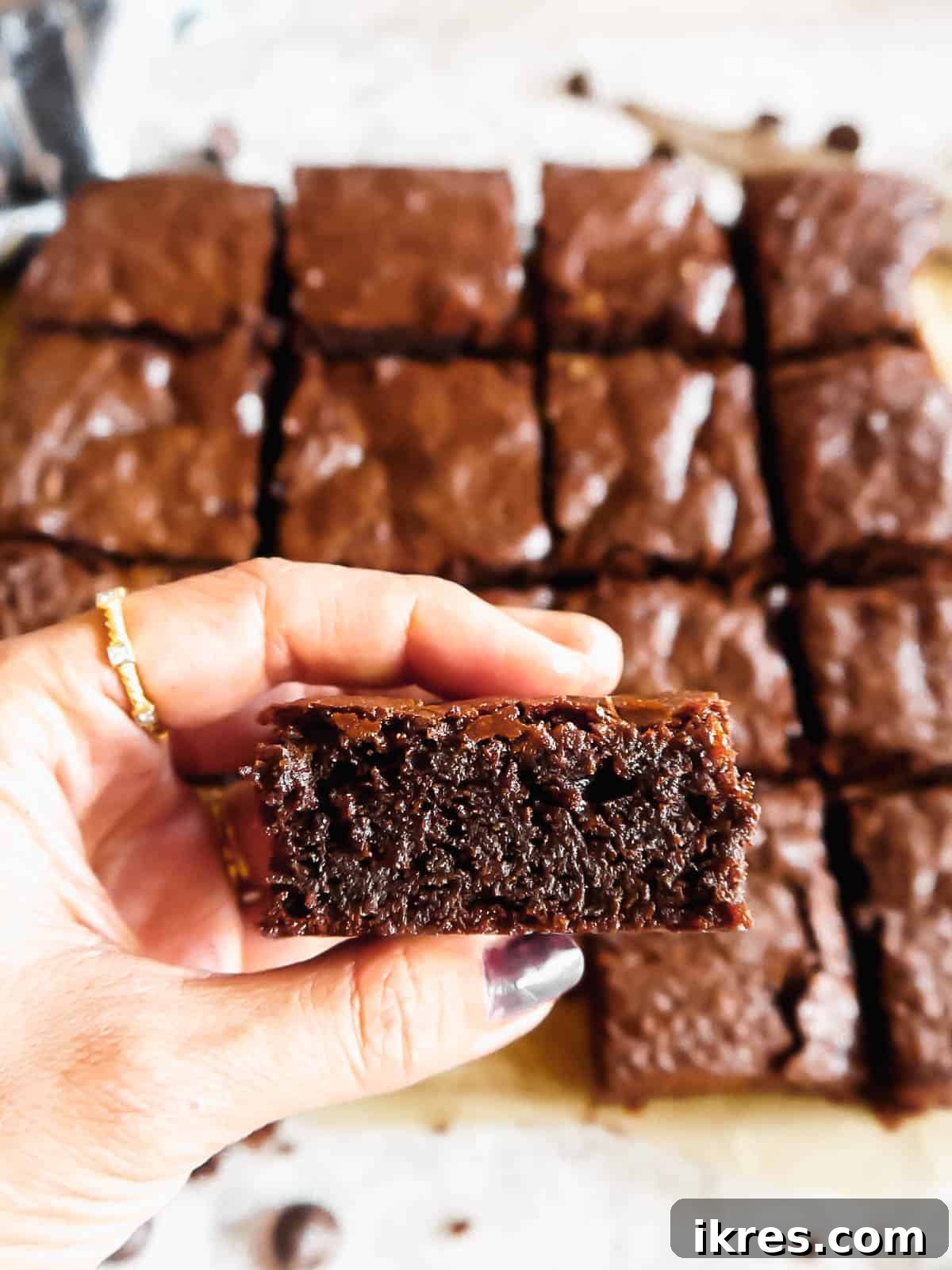 Deliciously Wholesome Almond Flour Brownies 13 A close-up of a hand holding a single, perfectly cut slice of fudgy paleo almond flour brownie, emphasizing its dense, rich texture.
