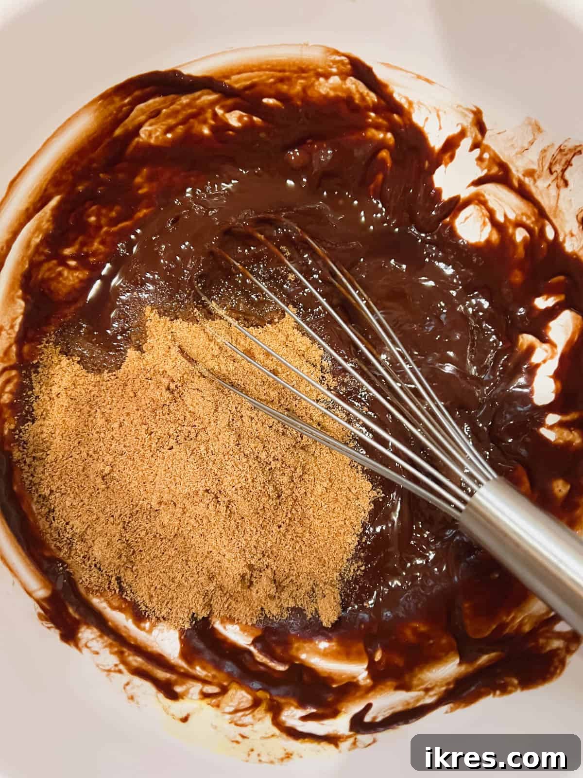 Deliciously Wholesome Almond Flour Brownies 6 Melted chocolate mixture in a bowl with coconut sugar and vanilla extract being added.